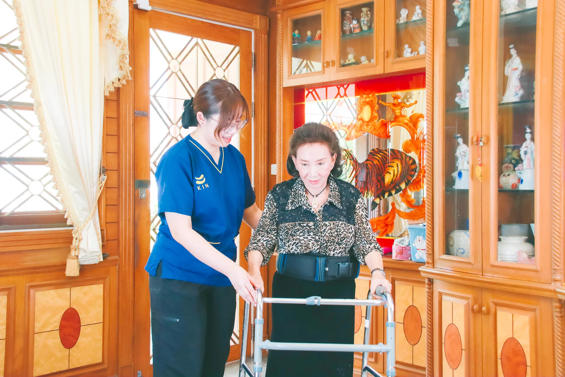 KIN physical therapist helping a stroke patient practise walking with a walker at home