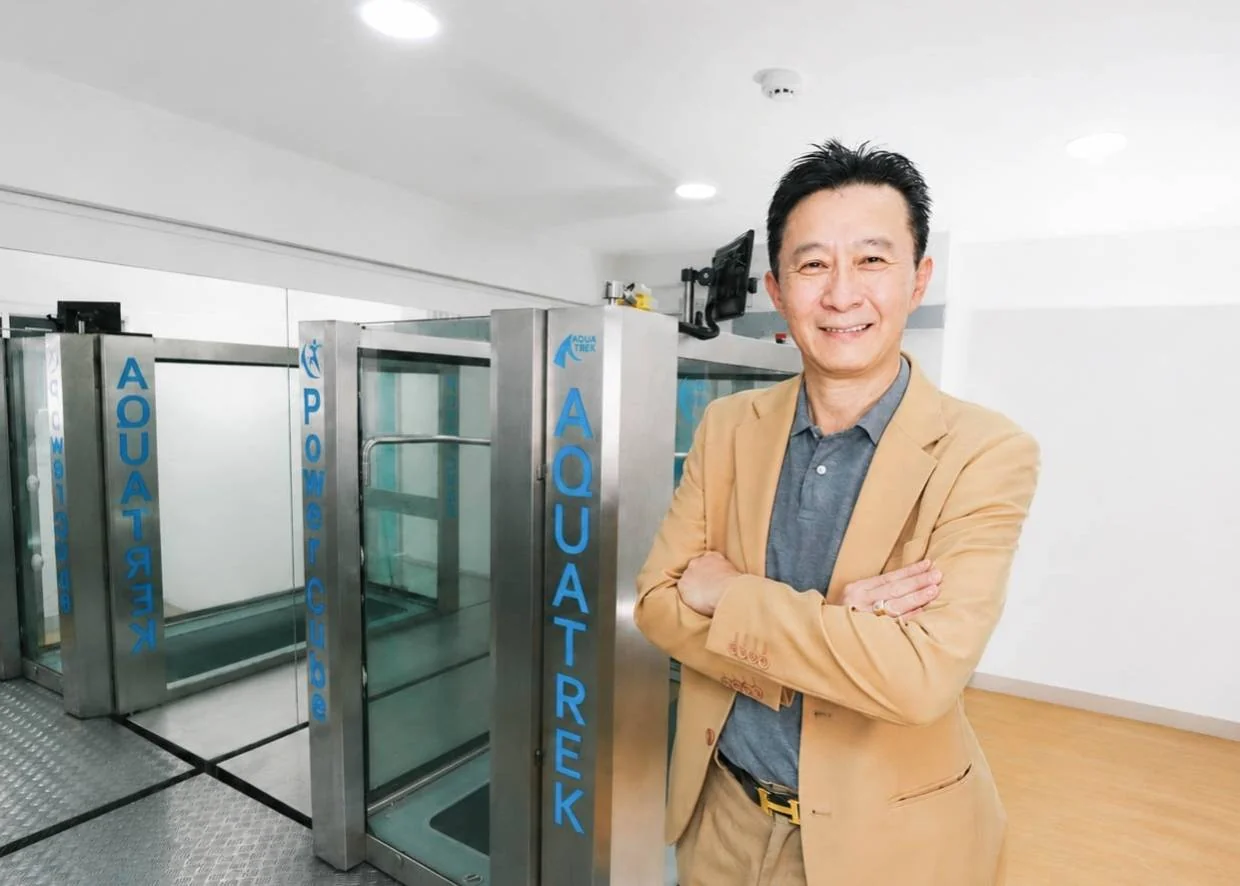 ดร.ธงชัย โชคถนอมทรัพย์ CEO และผู้ก่อตั้ง KIN Rehabilitation ยืนข้างเครื่อง Aquatic Treadmill สาขาลาดพร้าว 71 &mdash; Dr.Thongchai Chokthanomthreap Founder KIN Rehab